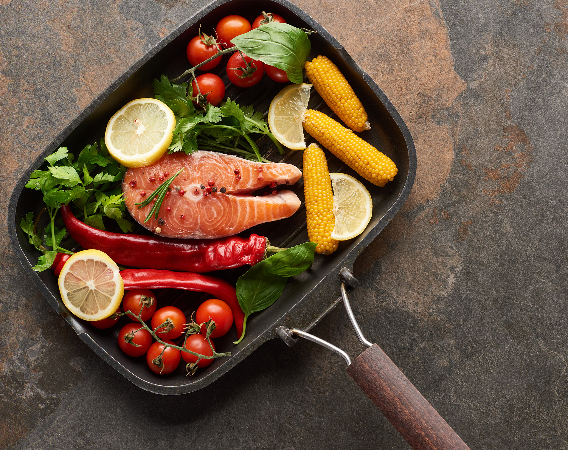 Top View of Raw Salmon With Vegetables, Lemon And Herbs in Grill Pan