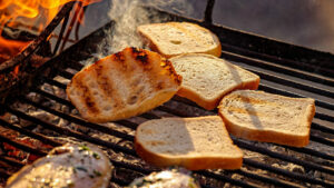Pieces of white bread grilling on the open fire on a barbecue | Bar-B-Clean